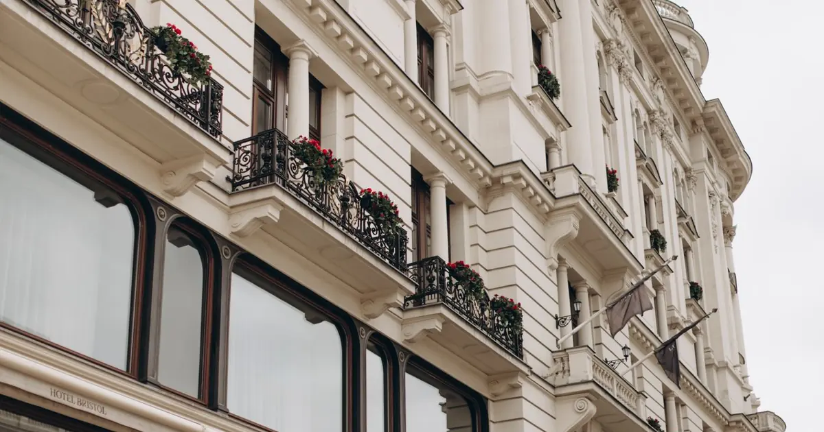 Fachada clásica de un hotel europeo con balcones y flores